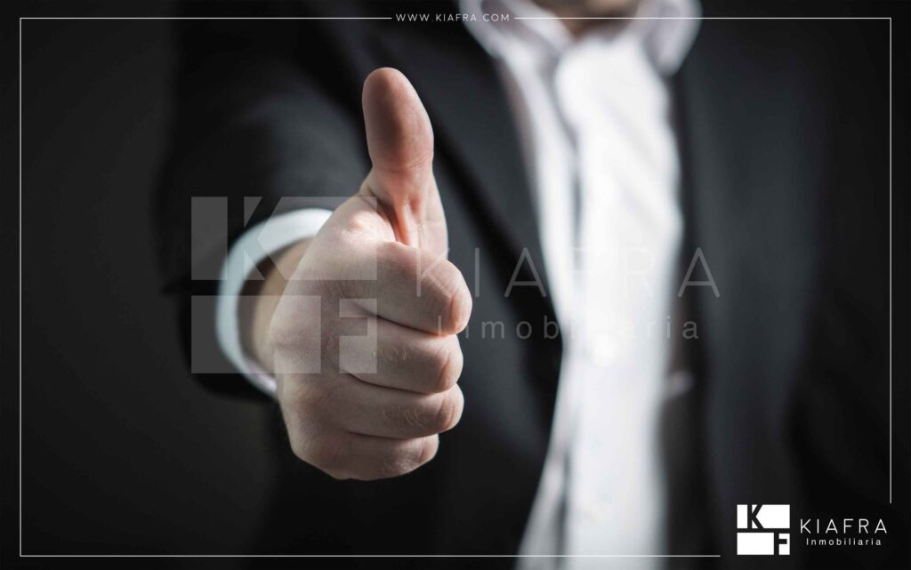 Ejecutivo mostrando su pulgar hacia arriba demostrando aprobación y excelencia, así como el marco de Inmobiliaria KIAFRA