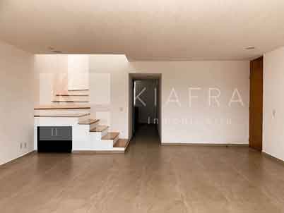 Estancia y escalera con la marca de agua de Inmobiliaria KIAFRA