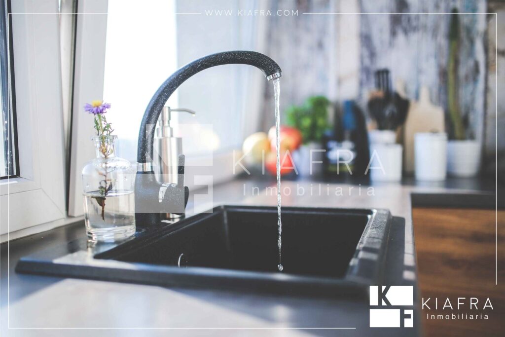 Grifo de agua con la llave abierta con la marca de agua de Inmobiliaria KIAFRA