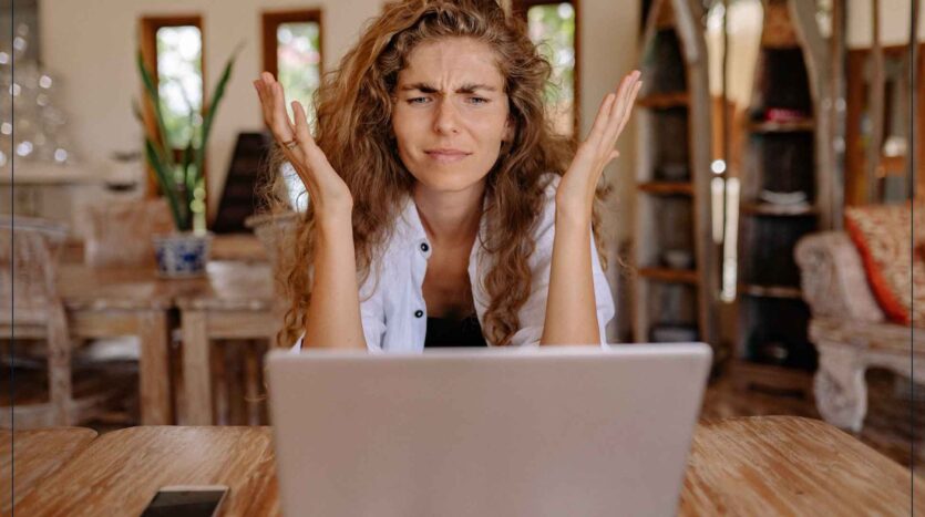 Mujer frente a una laptop demostrando confusión